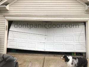 16x7 metal door with damage to all four sections, highly bent in the center