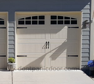 Image of a long panel bead board style metal carriage door in almond with arch stockton windows